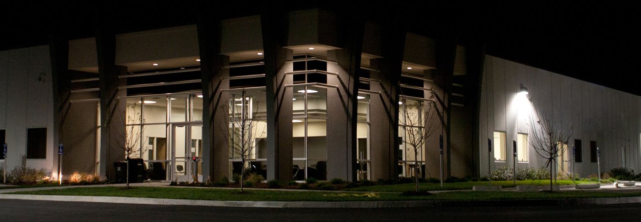 A distribution building lit at dusk, loading bays along the front