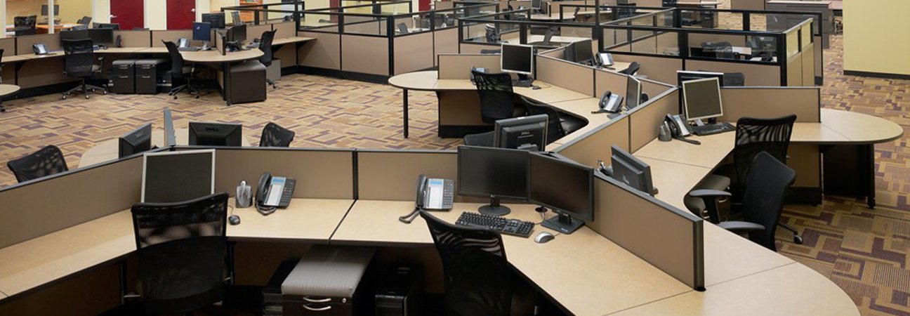 An open-plan customer service floor of workstations