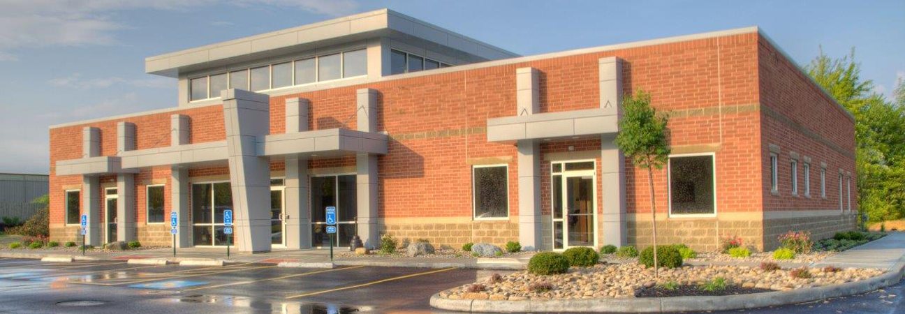 A brick and glass single-storey building with an entrance canopy